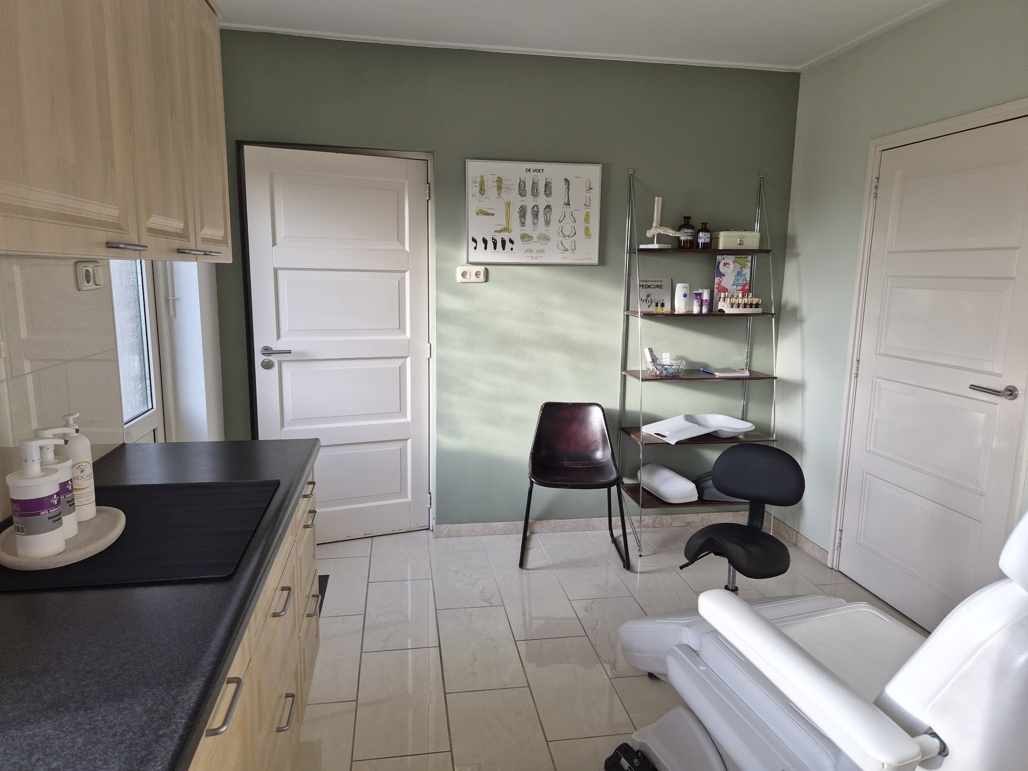De behandelkamer van VoetWijs met de pedicurestoel, werkkruk en instrumentenwagen